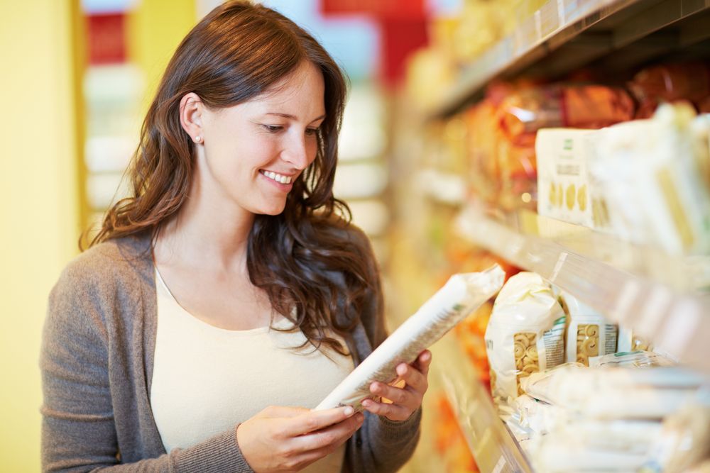 Frau im Supermarkt schaut auf Nudeln