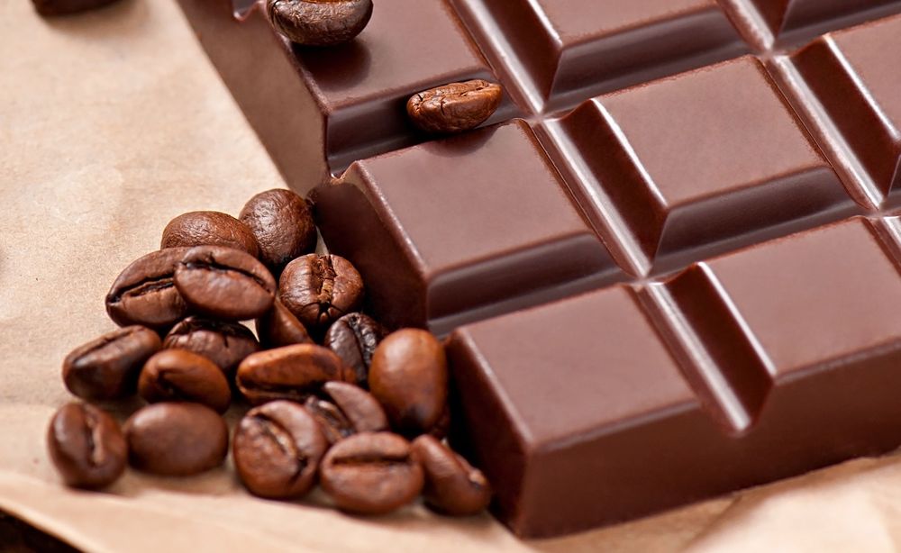 Chocolate and coffee beans on beige paper background